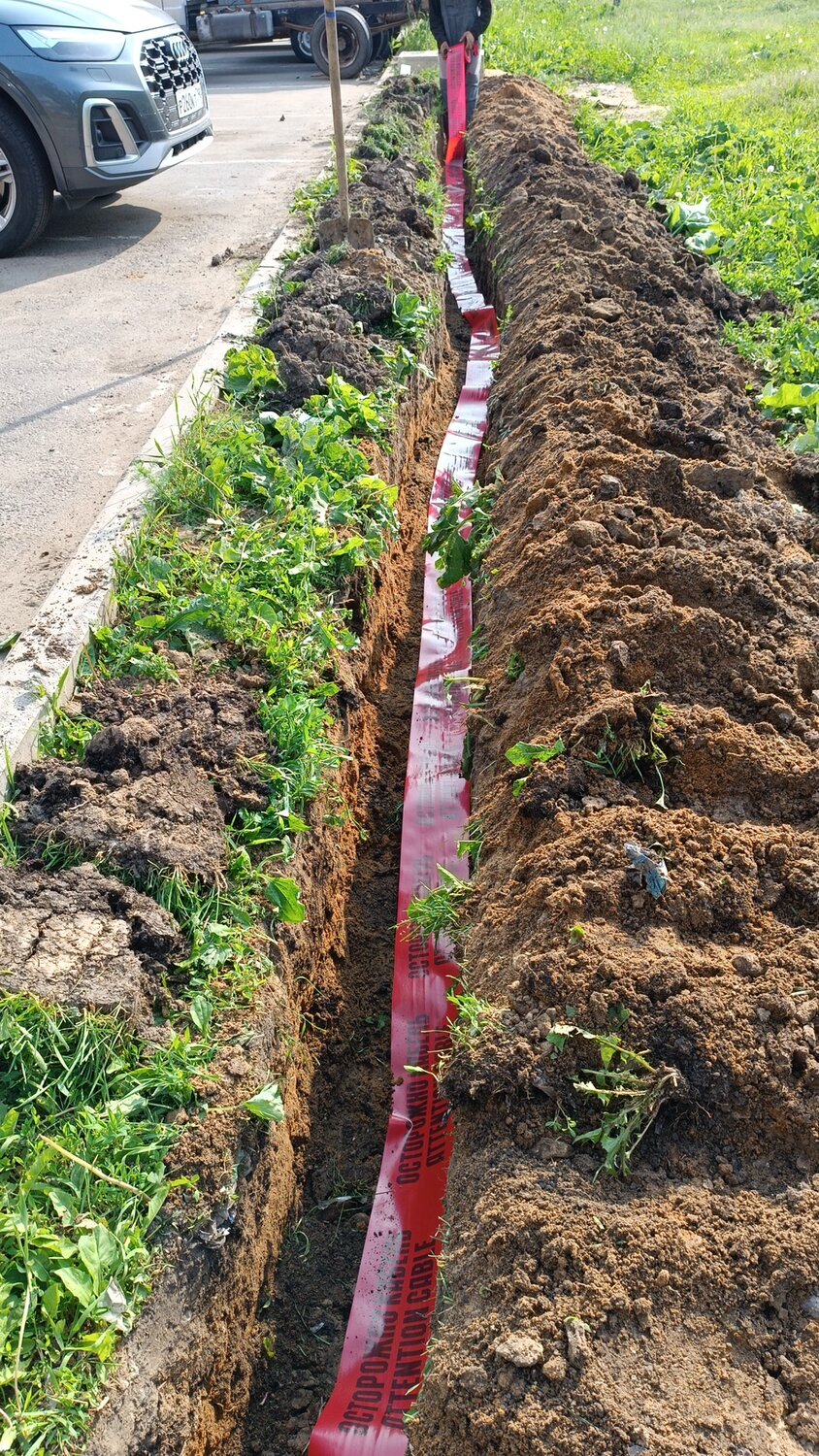 сигнальная лента в траншее, лента сигнальная осторожно кабель в траншее, прокладка кабеля в земле, траншея для кабеля, прокладка кабеля под землей