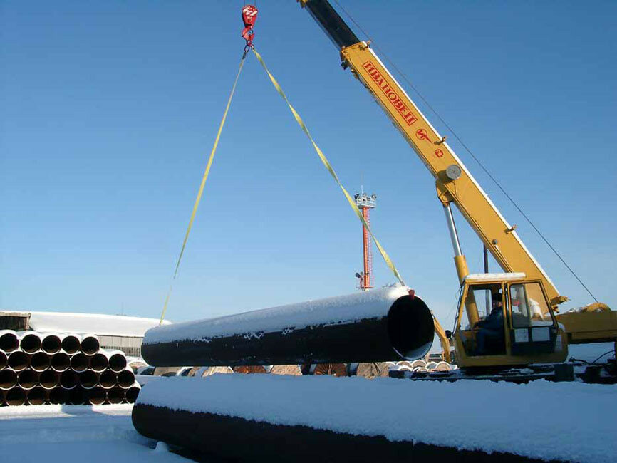 погрузка труб краном, строительство газопровода, труба большая, стрела трубоукладчика, кран трубоукладчик