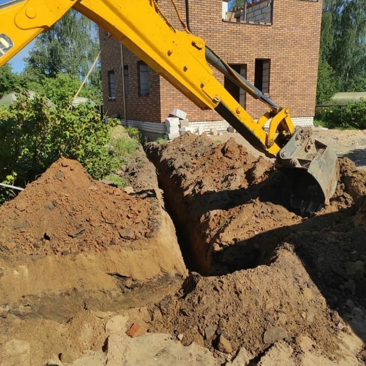 раскопанные траншеи экскаватором на строительной площадке, рытье траншей, экскаватор копает дренажную траншею, разработка траншей экскаватором, земляные работы