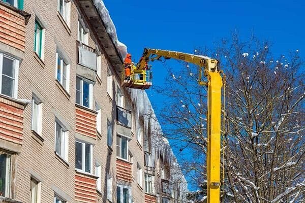 на автовышке к окну, многоквартирный дом, удаление сосулек с крыш с автовышки, электромонтаж на кровли крыши с автовышки, здание