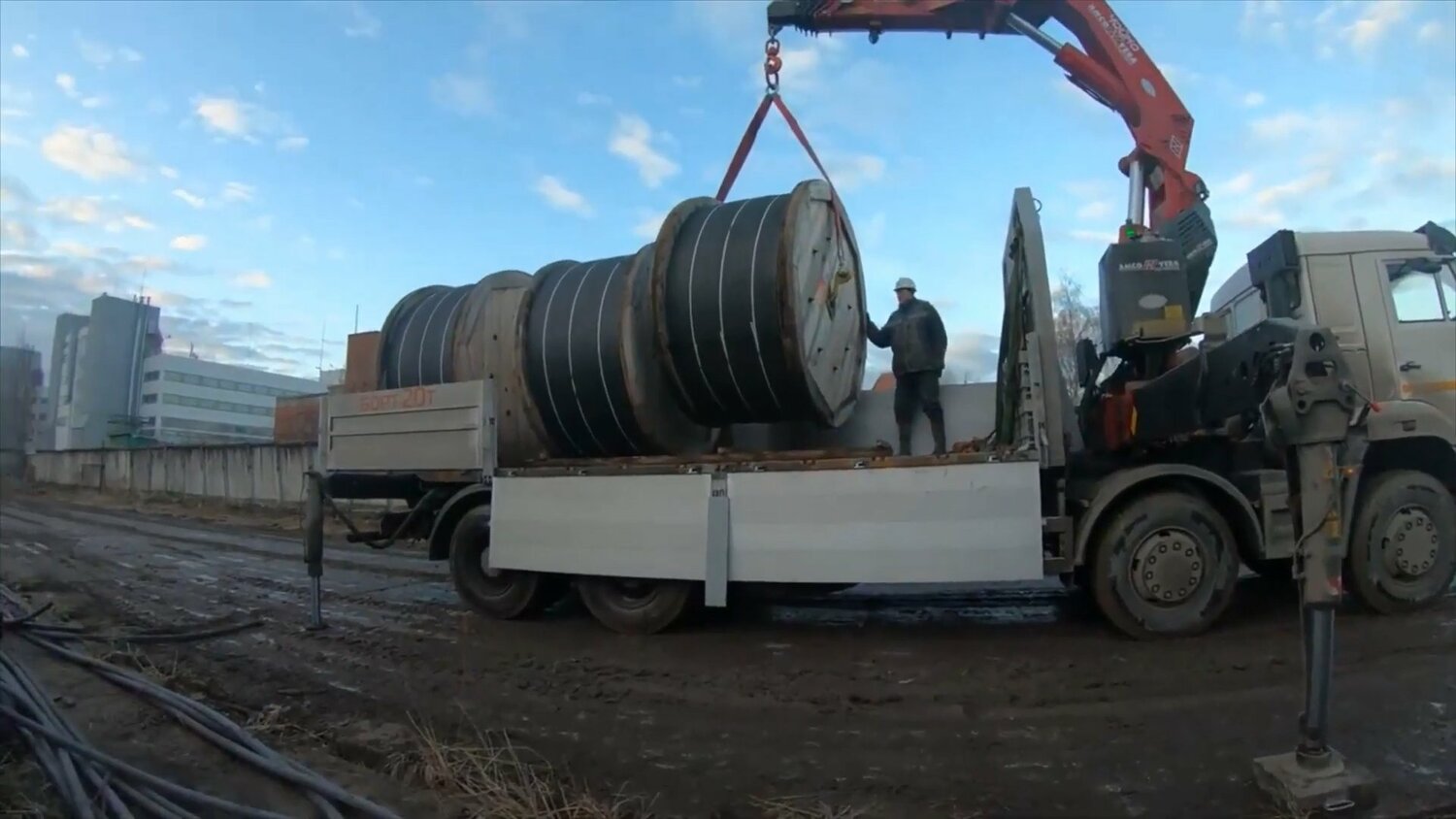 манипулятор грузит кабель, перевозка кабеля в барабанах, разгрузка барабанов с кабелем, разгрузка кабельных барабанов, машина для перевозки кабельных барабанов